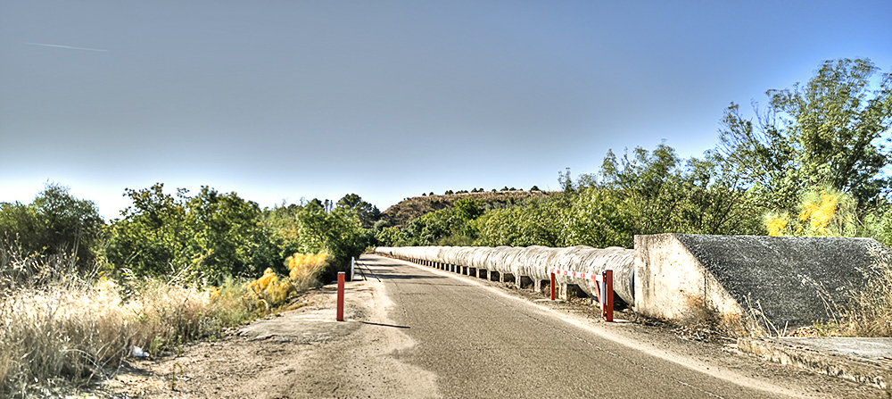 El puente del Cedena en Las Tamujas, los tubos y el Picacho del Torrejón al fondo